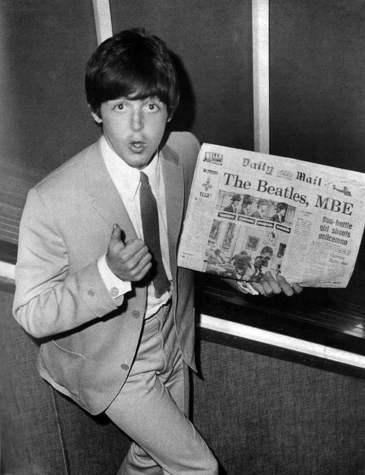 Paul McCartney with the Daily Mail newspaper bearing a headline about The Beatles' MBEs, 11 June 1965