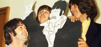Paul McCartney, George Harrison and Ringo Starr with a John Lennon cardboard cutout